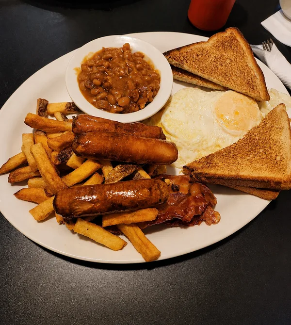 Bacon, sausages and eggs on a breakfast plate at Nena’s
